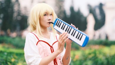 Anime cosplayer plays melodica in a vibrant park setting in Vietnam.