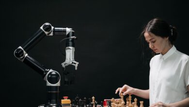 A woman plays chess against a robotic arm, showcasing AI innovation in a modern setting.
