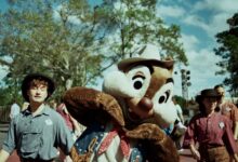 A costumed character interacting with park visitors outdoors in Bay Lake, Florida.