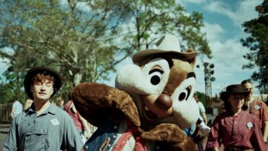 A costumed character interacting with park visitors outdoors in Bay Lake, Florida.