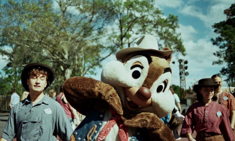A costumed character interacting with park visitors outdoors in Bay Lake, Florida.