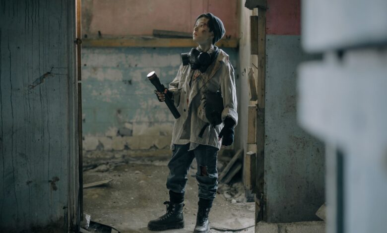 Young explorer in a gas mask investigates a ruined, desolate building with a flashlight.