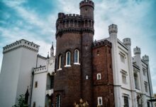 Stunning exterior of Kórnik Castle showcasing gothic revival architecture under blue skies.