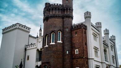 Stunning exterior of Kórnik Castle showcasing gothic revival architecture under blue skies.