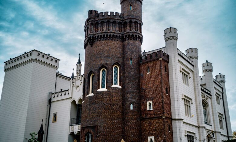 Stunning exterior of Kórnik Castle showcasing gothic revival architecture under blue skies.