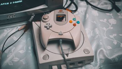 Close-up of a Sega Dreamcast console with controller and CRT monitor in a retro gaming setup.