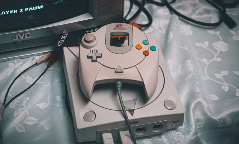 Close-up of a Sega Dreamcast console with controller and CRT monitor in a retro gaming setup.