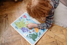 A child engaged with a colorful educational world map puzzle on a wooden floor, enhancing their problem-solving skills.
