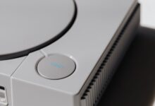 Detailed shot of a classic Sony PlayStation, highlighting the iconic open button and retro design.