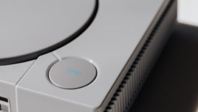 Detailed shot of a classic Sony PlayStation, highlighting the iconic open button and retro design.
