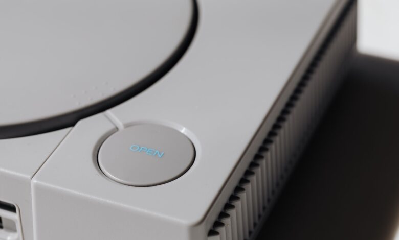 Detailed shot of a classic Sony PlayStation, highlighting the iconic open button and retro design.
