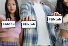 Young adults holding smartphones with TikTok hashtag, showcasing social media engagement.