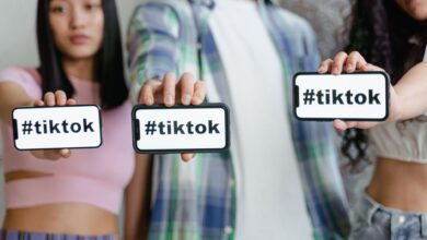 Young adults holding smartphones with TikTok hashtag, showcasing social media engagement.