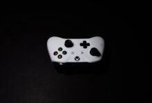 A close-up of a white Xbox controller on a black background, highlighting its modern design.