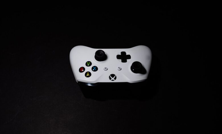 A close-up of a white Xbox controller on a black background, highlighting its modern design.