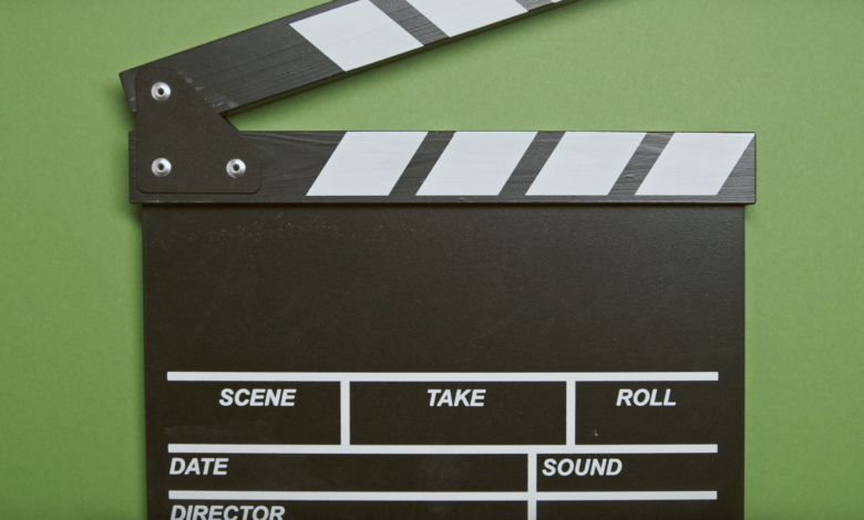 A classic film clapperboard on a green surface, essential for movie scenes.