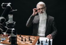Senior man strategizing in a chess game against a robot, showcasing AI in leisure activities.