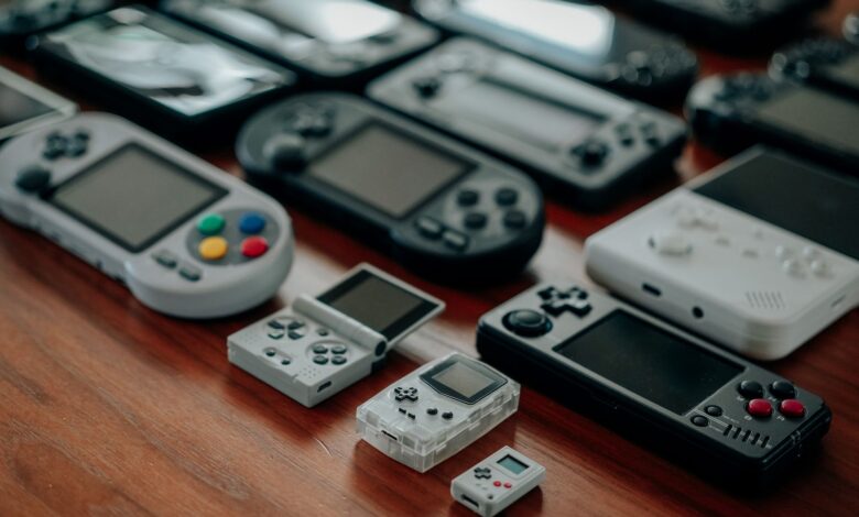Collection of diverse retro handheld gaming consoles on a wooden surface, showcasing classic designs and nostalgia.