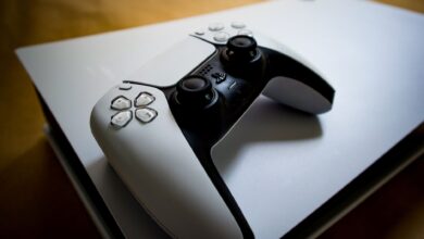 Detailed shot of a PlayStation 5 controller resting on the console, highlighting modern gaming design.