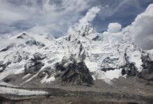 Stunning capture of snow-capped peaks in the Himalayas under a cloudy sky, Khumjung, Nepal.