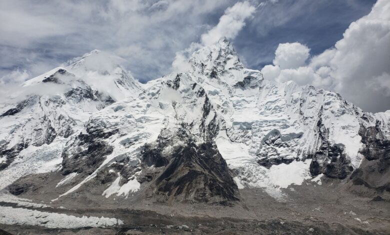 Stunning capture of snow-capped peaks in the Himalayas under a cloudy sky, Khumjung, Nepal.