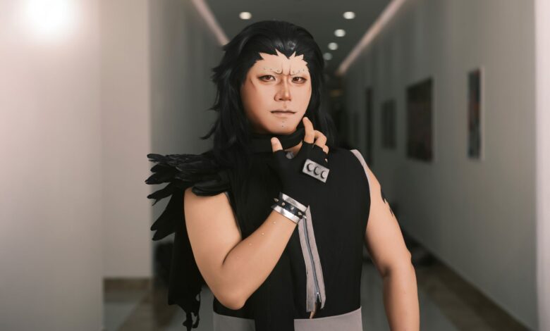 Cosplayer dressed as a dramatic anime character poses confidently in an indoor corridor.