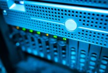 Focused view of a modern data server rack with blinking lights in a blue-lit environment.