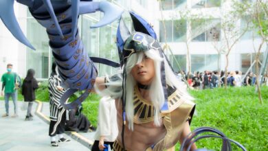 Young adult in cosplay costume at outdoor event with futuristic armor.