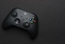 Closeup of a black gaming controller on a dark backdrop, perfect for tech themes.