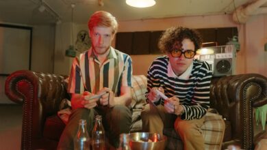 Two young men enjoying a video game night in a retro-inspired basement setting.
