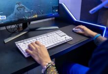 Close-up of a person gaming on a PC with a colorful setup and gaming accessories.