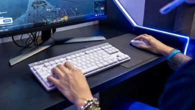 Close-up of a person gaming on a PC with a colorful setup and gaming accessories.
