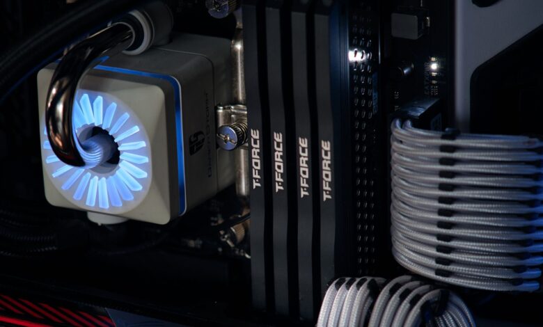 Detailed close-up of a computer cooling system featuring T-FORCE components and blue lighting.