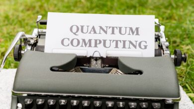 A typewriter with 'Quantum Computing' text outdoors on grass, blending old and new technologies.