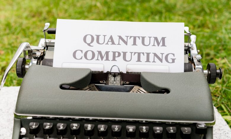 A typewriter with 'Quantum Computing' text outdoors on grass, blending old and new technologies.
