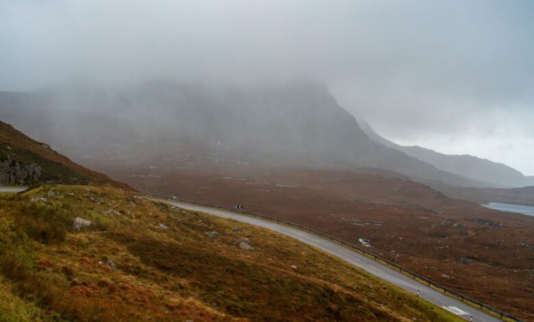 A winding road through a misty mountain landscape offering a serene and atmospheric view.