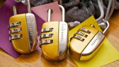 Three gold combination padlocks with colorful tags, symbolizing security and travel.