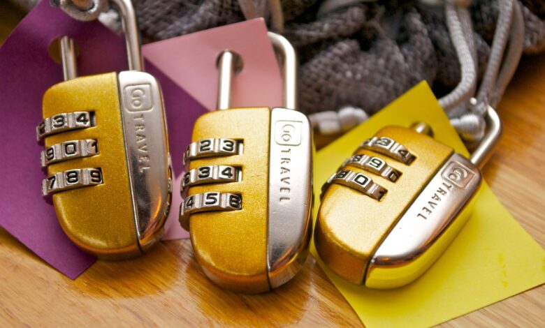 Three gold combination padlocks with colorful tags, symbolizing security and travel.