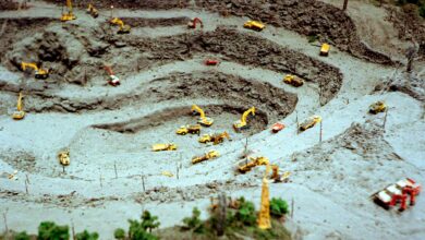 Aerial shot of a toy construction site with miniature bulldozers and excavators.