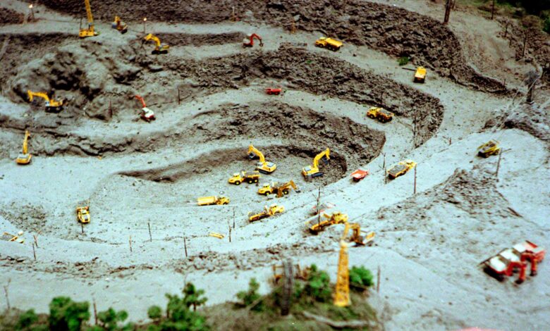 Aerial shot of a toy construction site with miniature bulldozers and excavators.