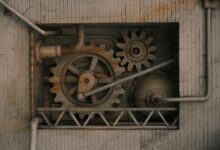 Detailed view of mechanical gears and pipes built into a brick wall, showcasing industrial design.