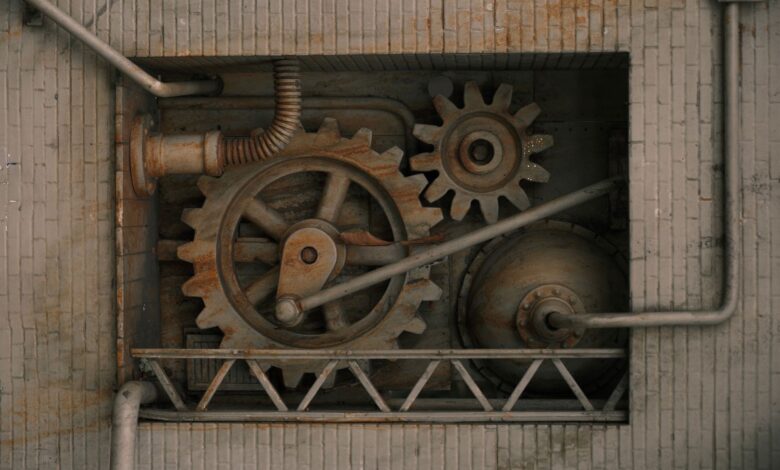 Detailed view of mechanical gears and pipes built into a brick wall, showcasing industrial design.
