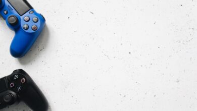 Blue and black PlayStation game controllers on minimal white surface. Perfect for gaming and technology themes.