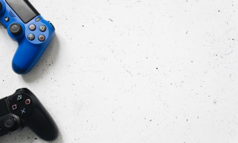 Blue and black PlayStation game controllers on minimal white surface. Perfect for gaming and technology themes.