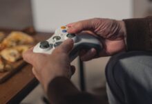 A senior adult holding a game controller, enjoying a leisurely moment indoors.