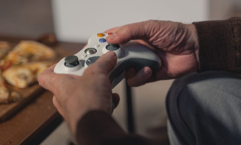 A senior adult holding a game controller, enjoying a leisurely moment indoors.