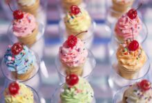 Vibrant cupcake cones topped with cherries and sprinkles, a festive sweet treat.