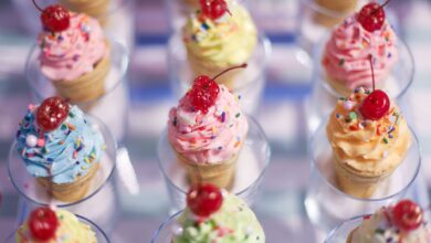 Vibrant cupcake cones topped with cherries and sprinkles, a festive sweet treat.