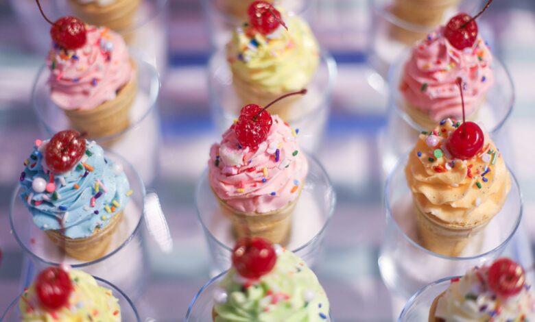 Vibrant cupcake cones topped with cherries and sprinkles, a festive sweet treat.