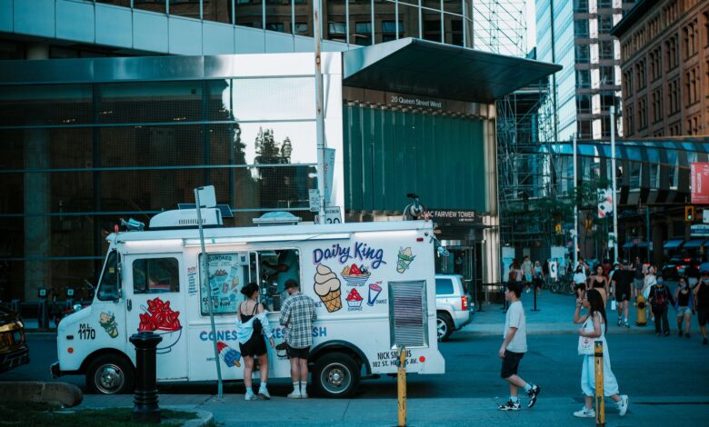 A vibrant street scene in Toronto featuring an ice cream truck and pedestrians.